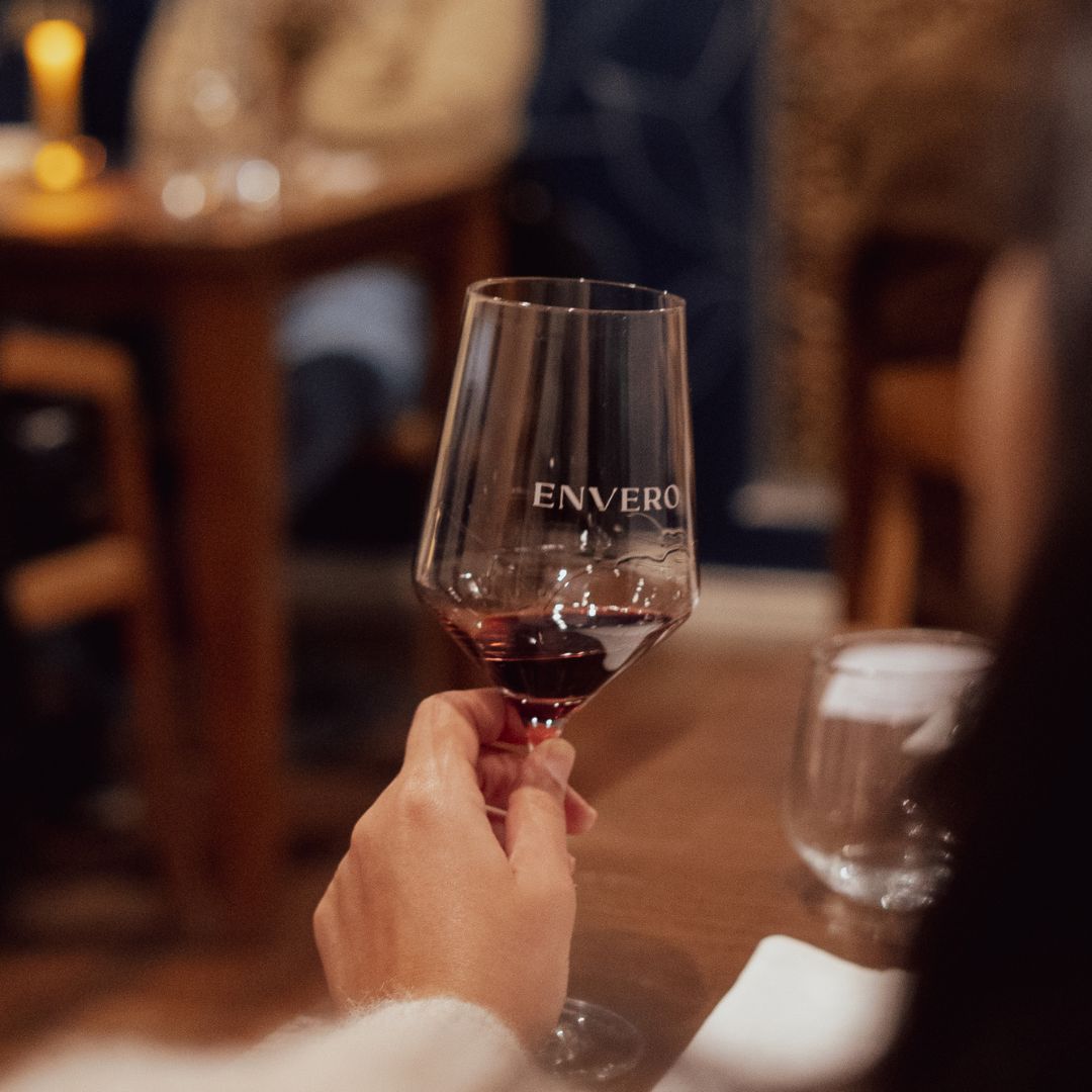 Copa de vino con logo Envero en ambiente del wine bar en Santa Fe